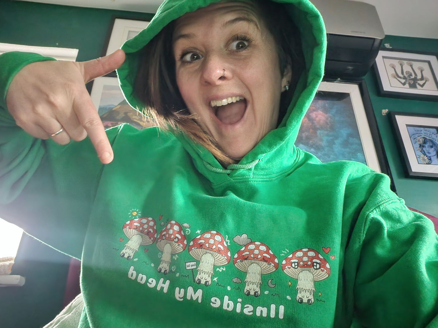 Happy woman wearing a green Iinside my Head Mushroom Hoodie